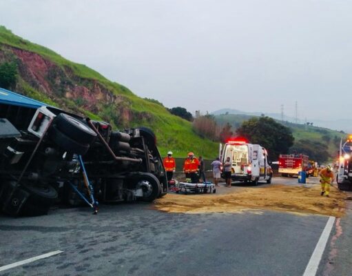 Carreta com container tomba na Dutra no Km 70 e motorista fica preso às ferragens